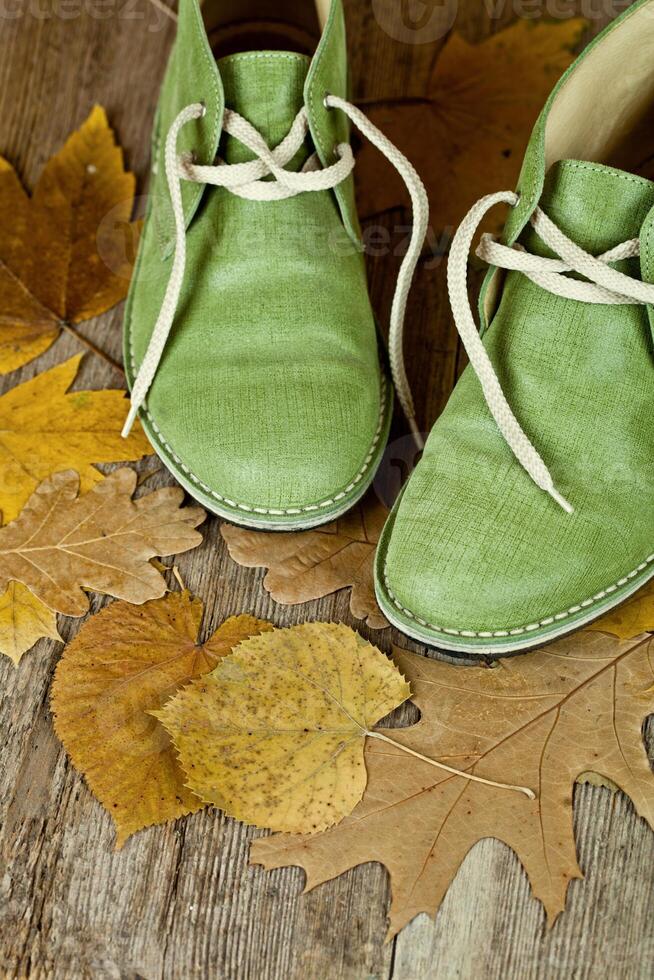 pair of green leather boots and yellow leaves photo