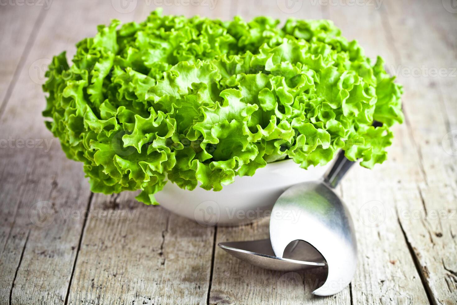lettuce salad in a bowl and spoons photo