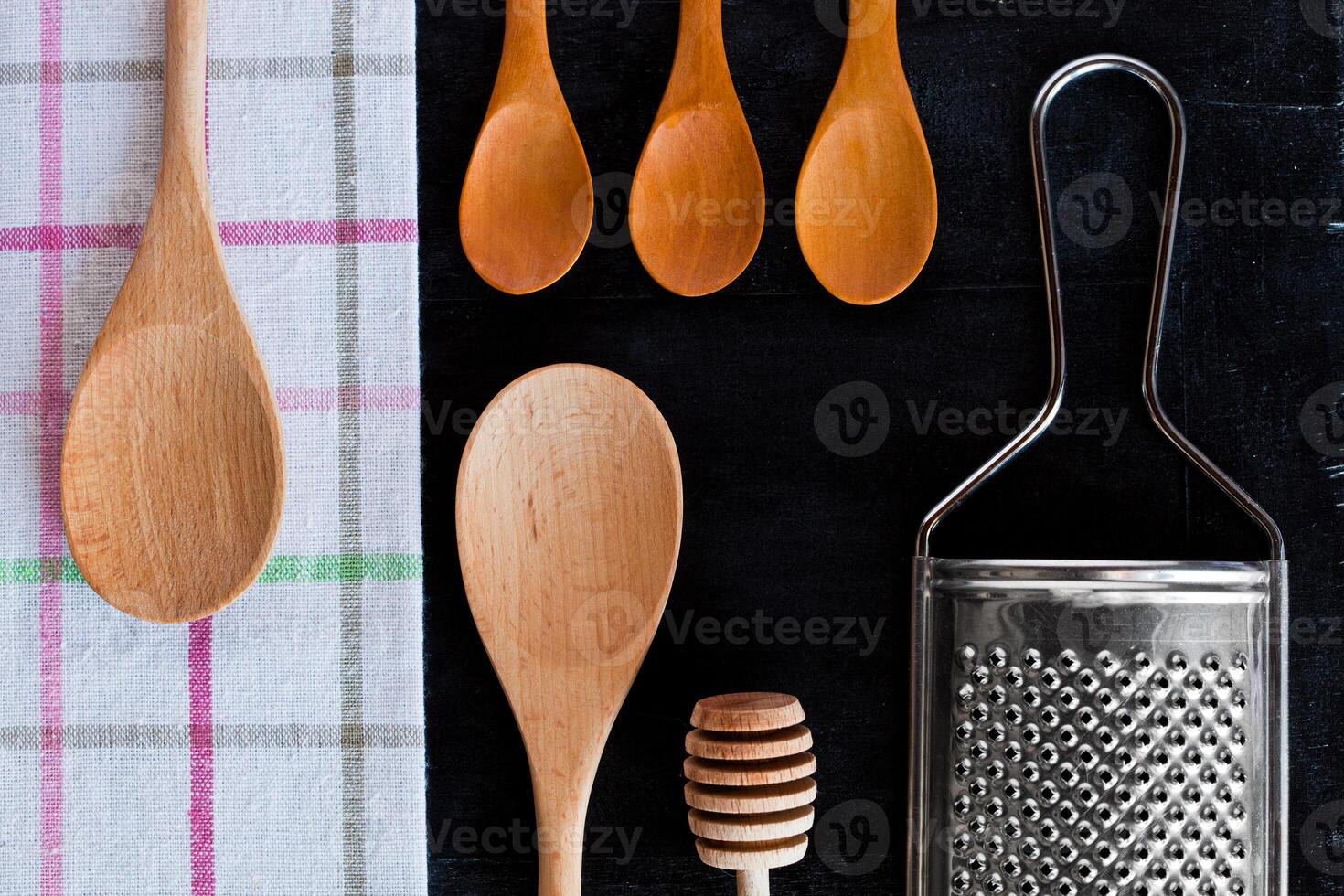 wooden spoons, metal grater and tablecloth photo