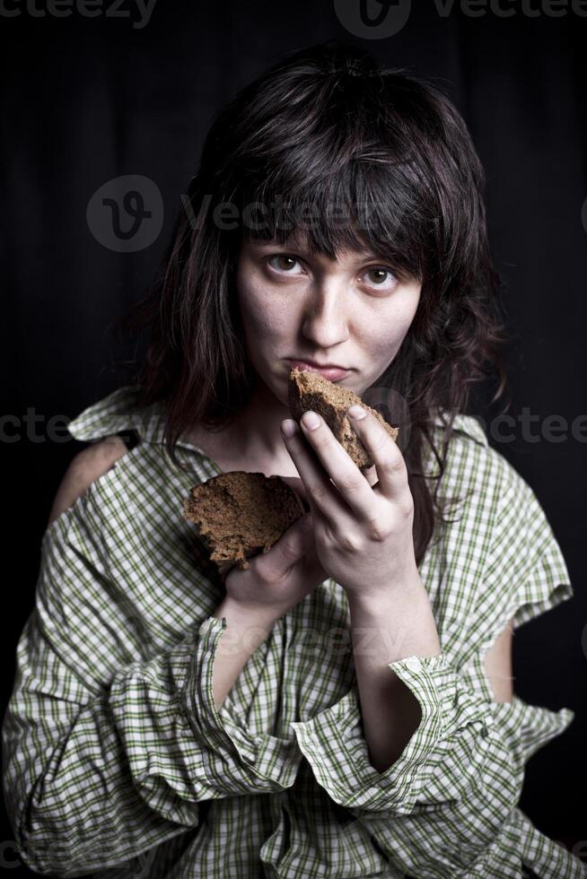 Poor beggar woman with a piece of bread. photo