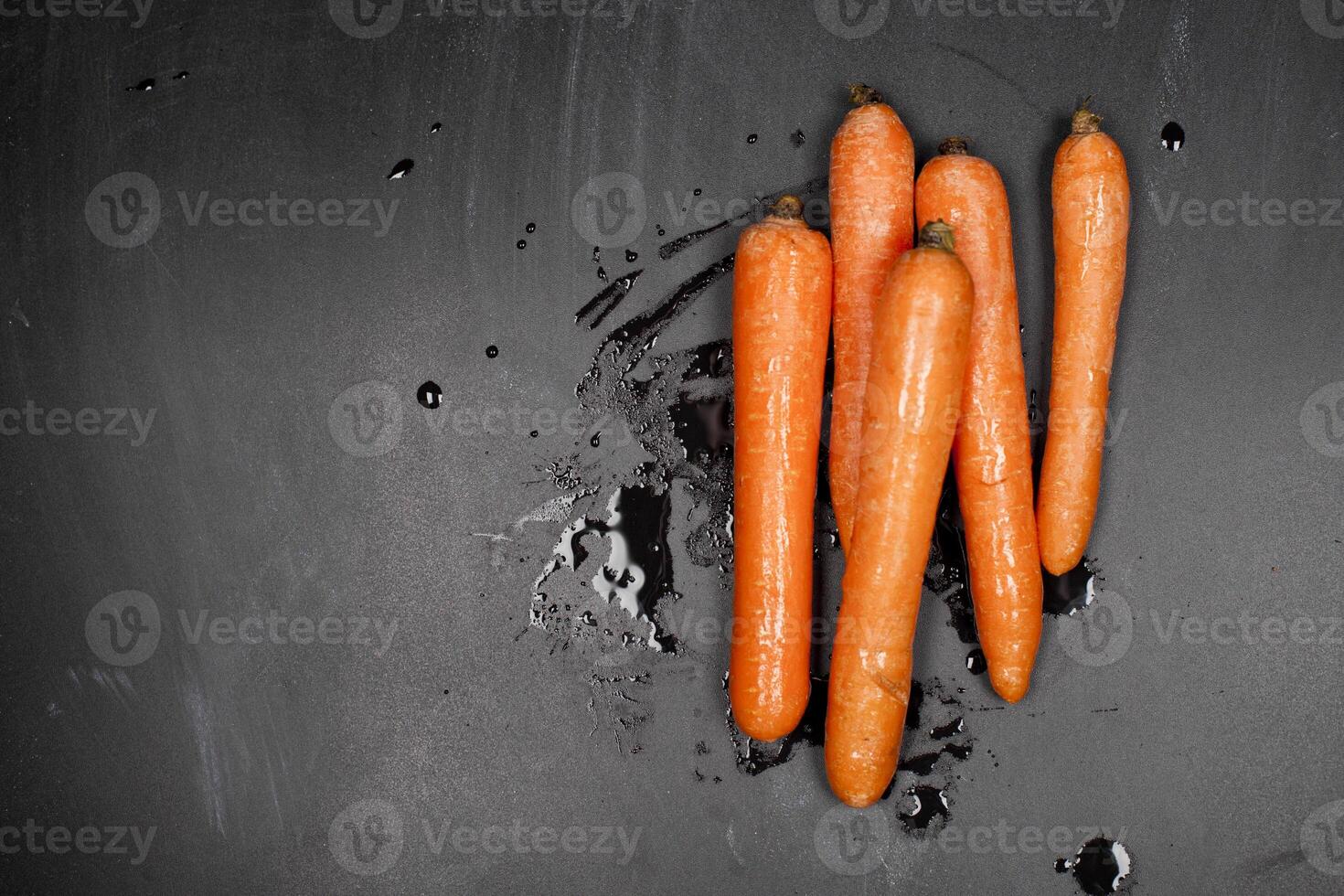 Fresh organic wet carrots on black background. photo