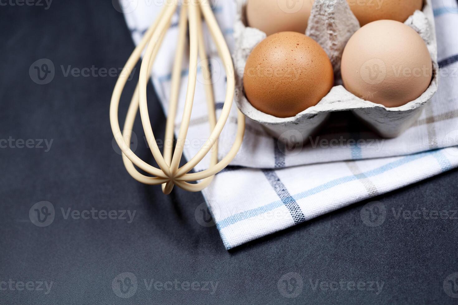 Eggs in cardboard box, towel and whisker closeup on backboard background. photo