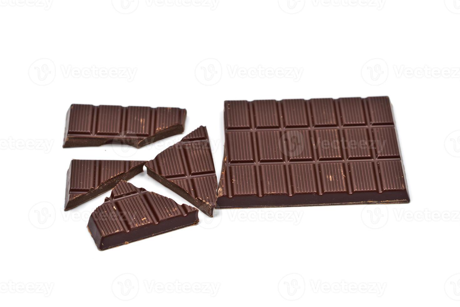 Broken dark chocolate bar isolated on white. photo