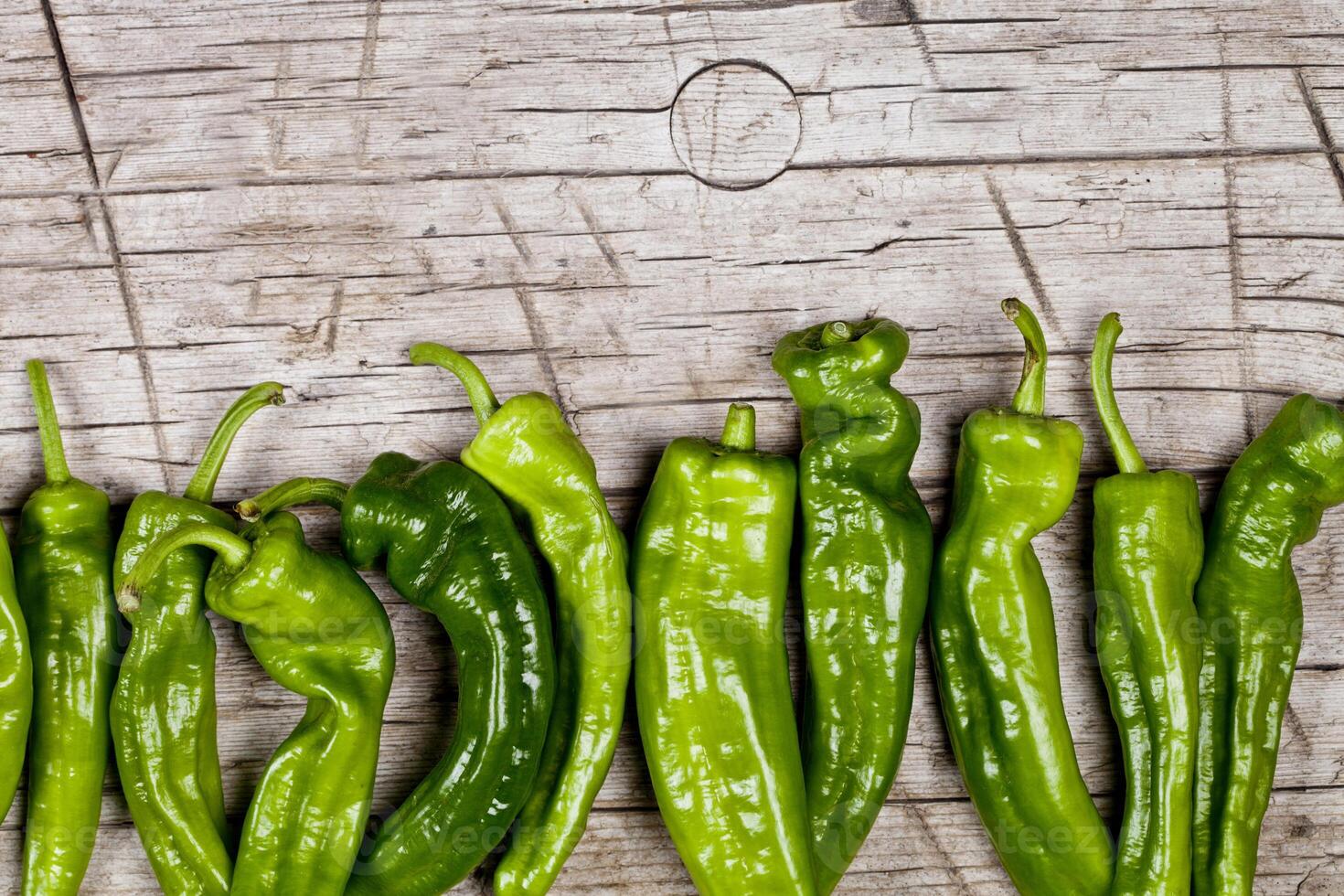 Fresh green raw peppers on rustic wooden table background. photo