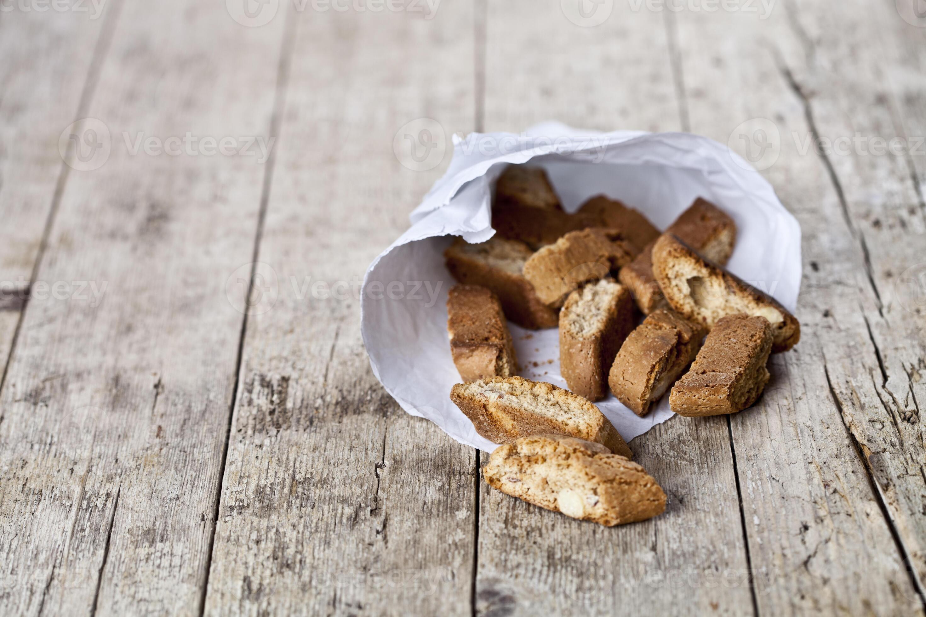 Traditional Italian cookies cantuccini on white paper bag on ructic ...