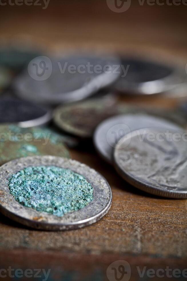Pile of different ancient copper coins ccloseup on rustic wooden table background. photo