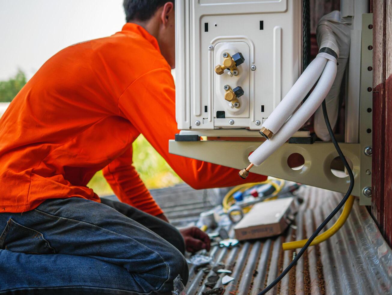 Air conditioning technicians install new compressor air in homes, Repairman fix air conditioning systems, Male technician service for repair and maintenance of air conditioners photo