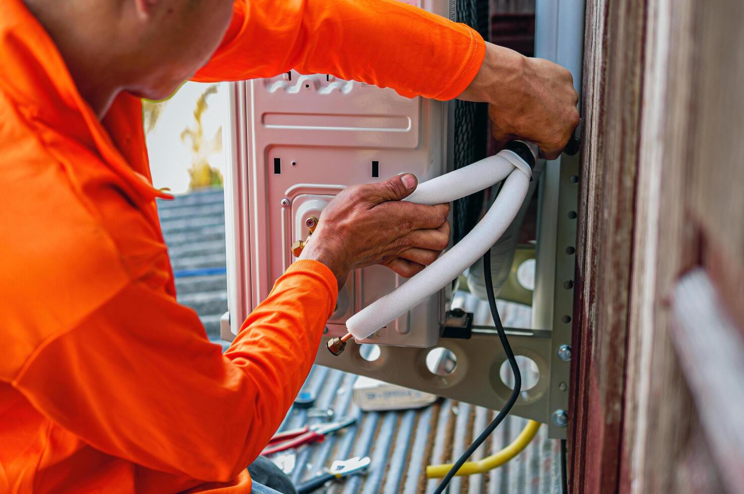 Air conditioning technicians install new compressor air in homes, Repairman fix air conditioning systems, Male technician service for repair and maintenance of air conditioners photo