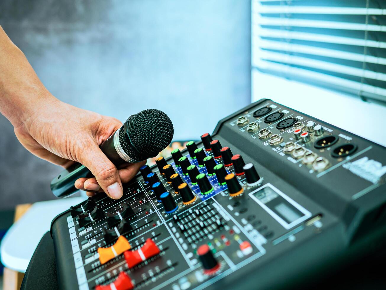 Hand Sound engineer holding microphone on sound mixer in live broadcasting studio producer for sound record control system production and audio equipment and music instrument photo