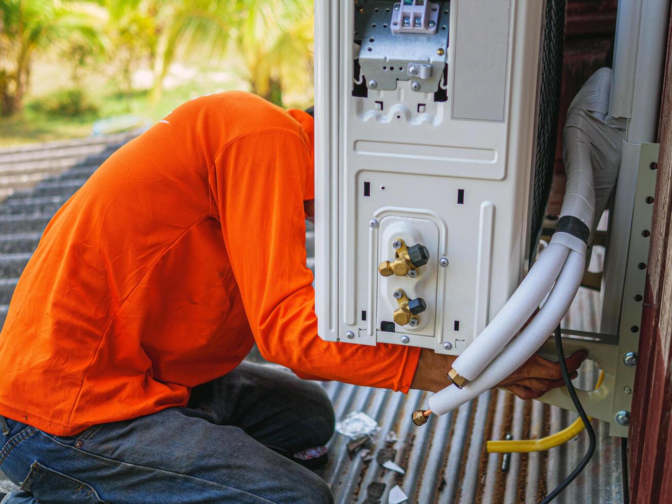 Air conditioning technicians install new compressor air in homes, Repairman fix air conditioning systems, Male technician service for repair and maintenance of air conditioners photo