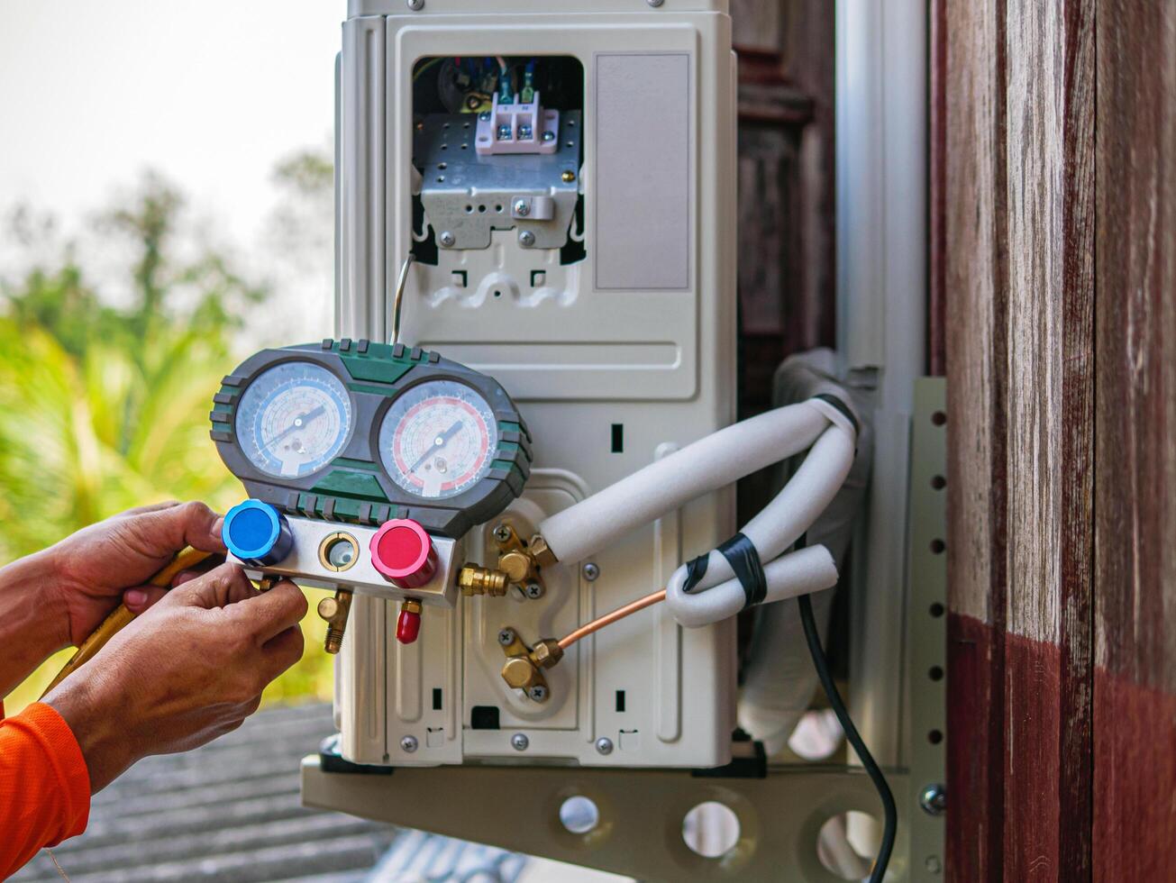 Air conditioning technicians install new compressor air using monitor tool to check air conditioner system, Repairman HVAC system service technician using measuring manifold gauge checking photo