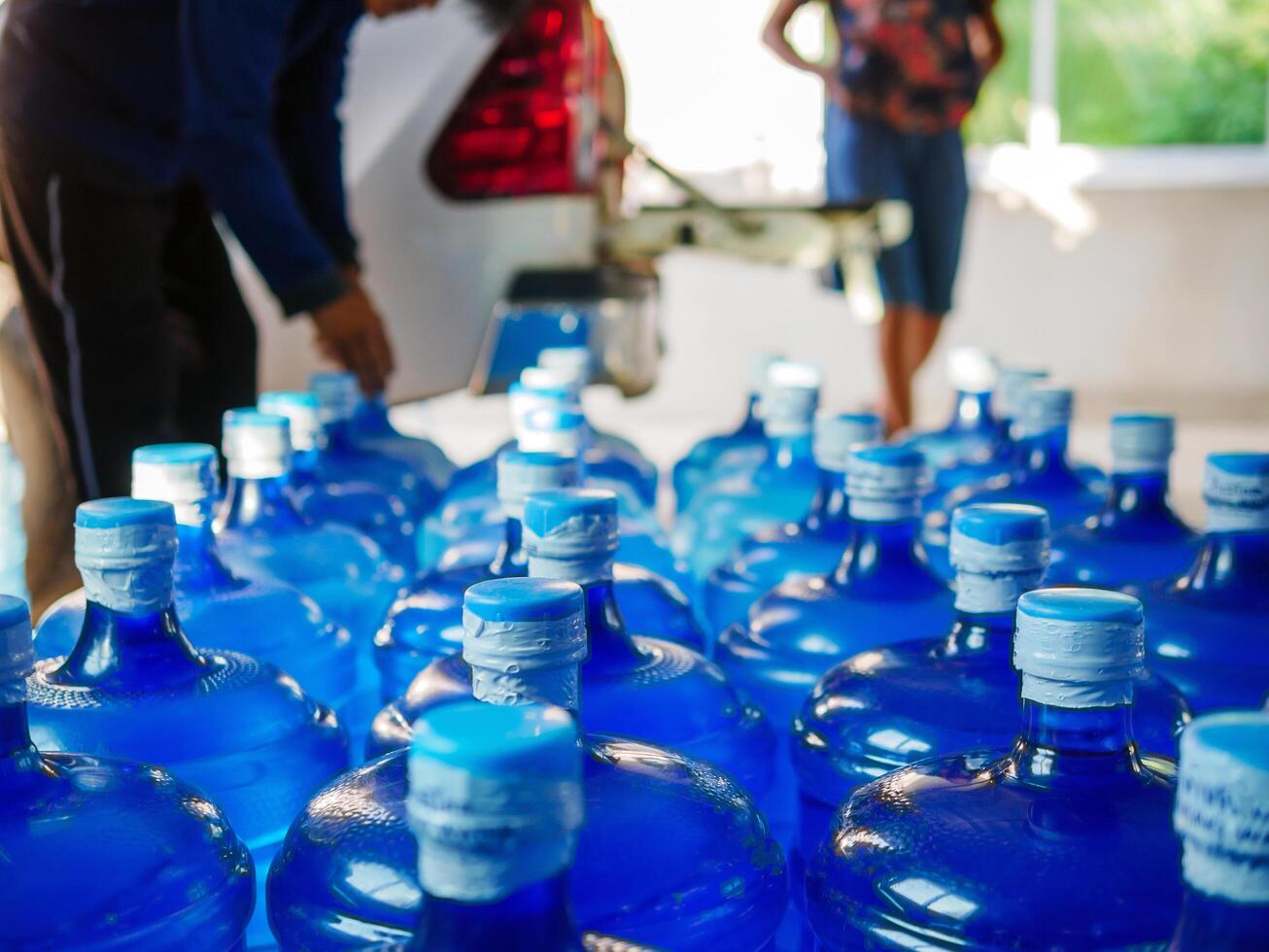 Drinking water clear and clean in blue gallon arranged in a row Prepare to lift into the back of a transport truck purified drinking water inside the production line to prepare for sale. Water drink photo