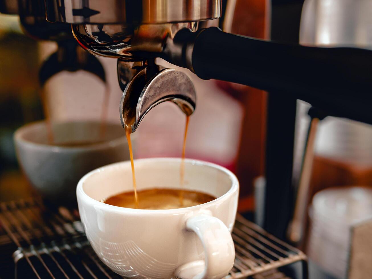 Close-up of espresso pouring from the coffee machine into a coffee cup. Professional coffee brewing,coffee crema photo
