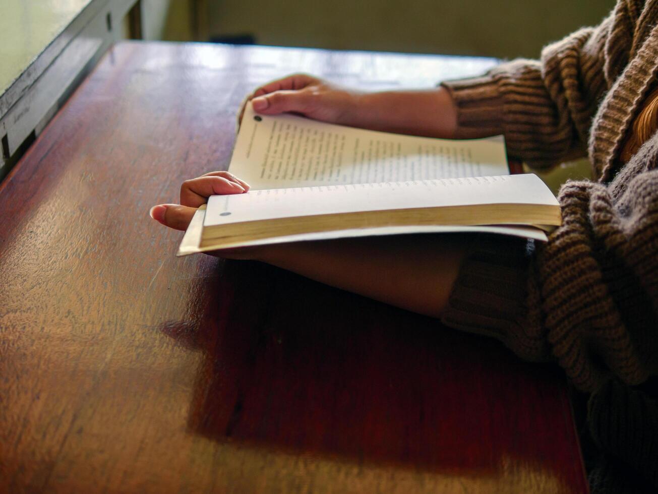 Learning, education Hand of Senior woman sitting reading fiction book on wooden table,relax and enjoy books. photo