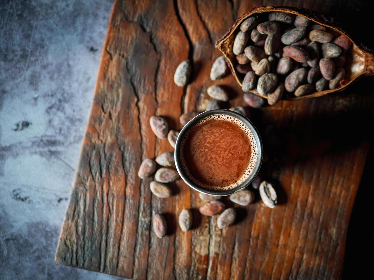 Natural craft cocoa drink, organic healthy chocolate drink with brown cocoa beans and dry cacao pod.Top view,above photo