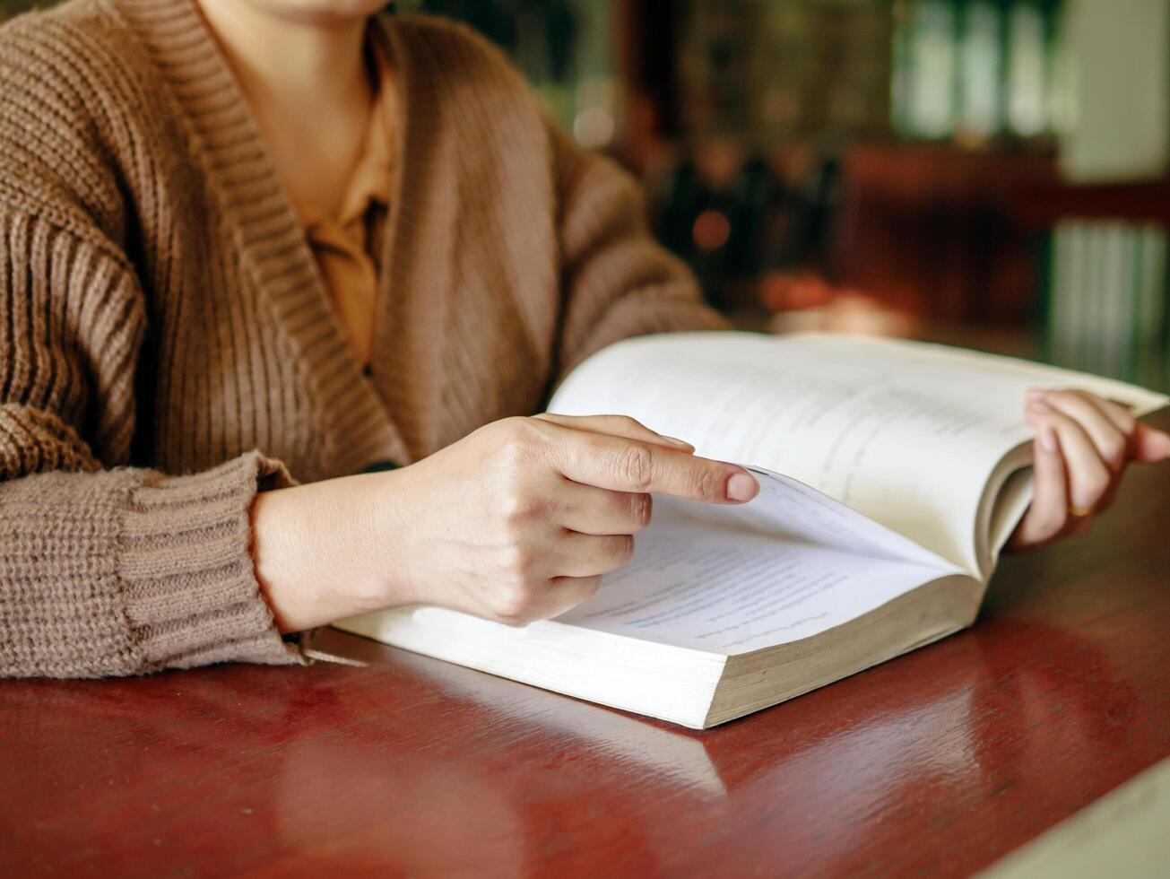 Learning, education Hand of Senior woman sitting reading fiction book on wooden table,relax and enjoy books. photo