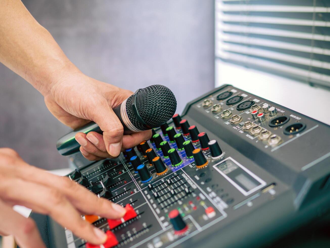 Hand Sound engineer holding microphone on sound mixer in live broadcasting studio producer for sound record control system production and audio equipment and music instrument photo