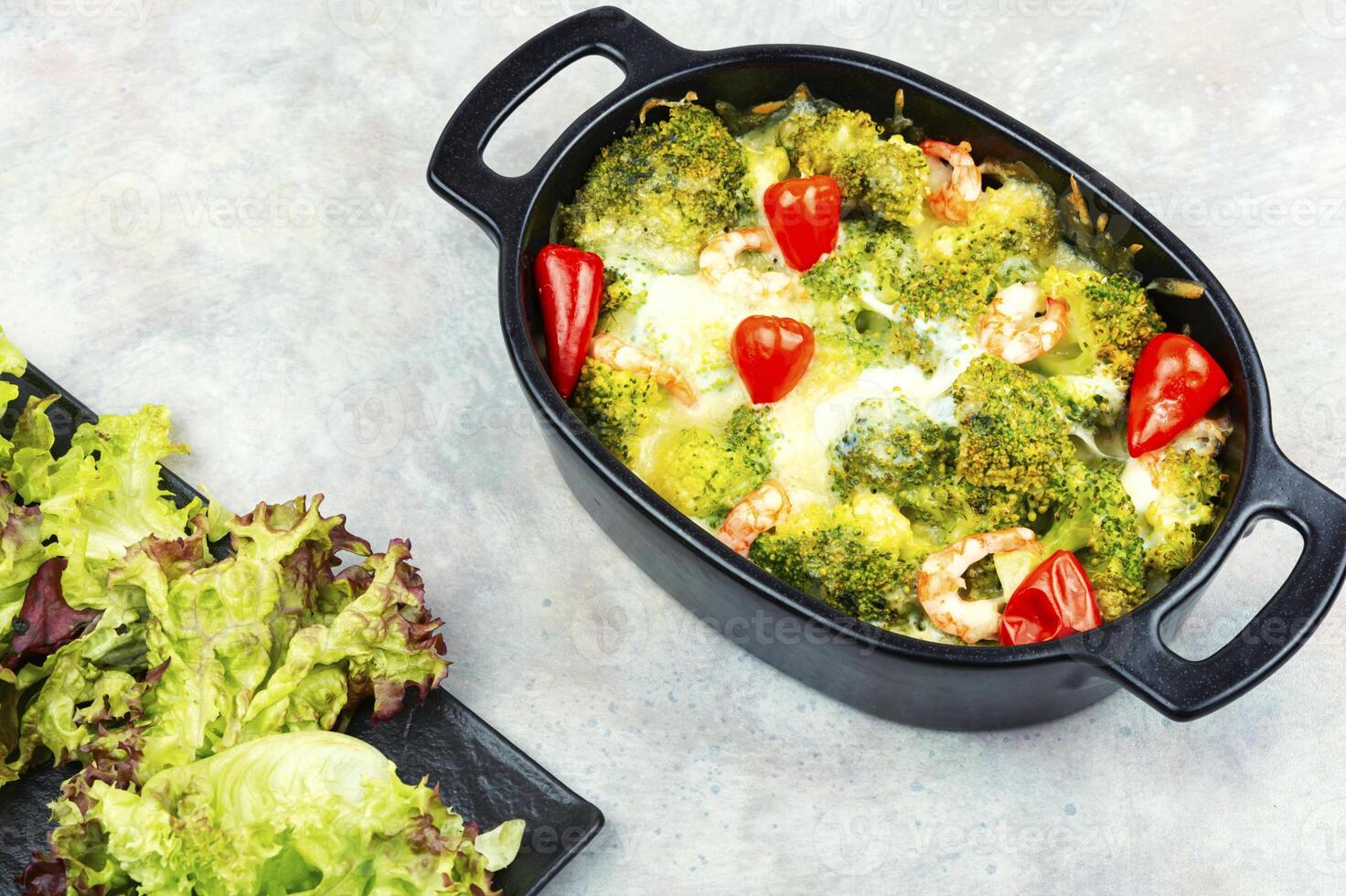 Oven baked broccoli topped with melted mozzarella and prawns. photo