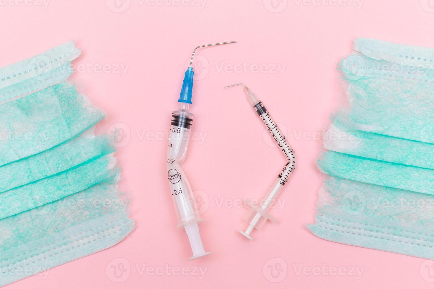 Anti Vaccine Movement and Anti Mask Concept - Broken Medical Syringe and Green Torn Medical Face Mask on the Pink Background. Pandemic and Lockdown End - Top View, Flat Lay photo