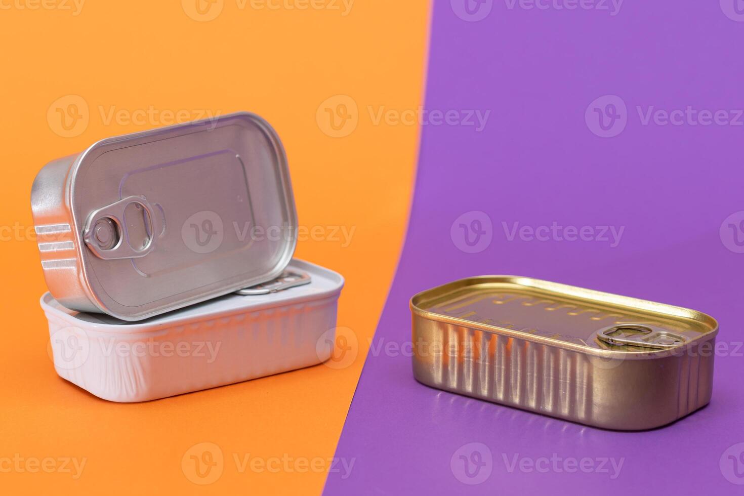 A Group of Stacked Tin Cans with Blank Edges on Split Orange and Violet Background. Canned Food. Different Aluminum Cans for Safe and Long Term Storage of Food. Steel Sealed Food Storage Containers photo