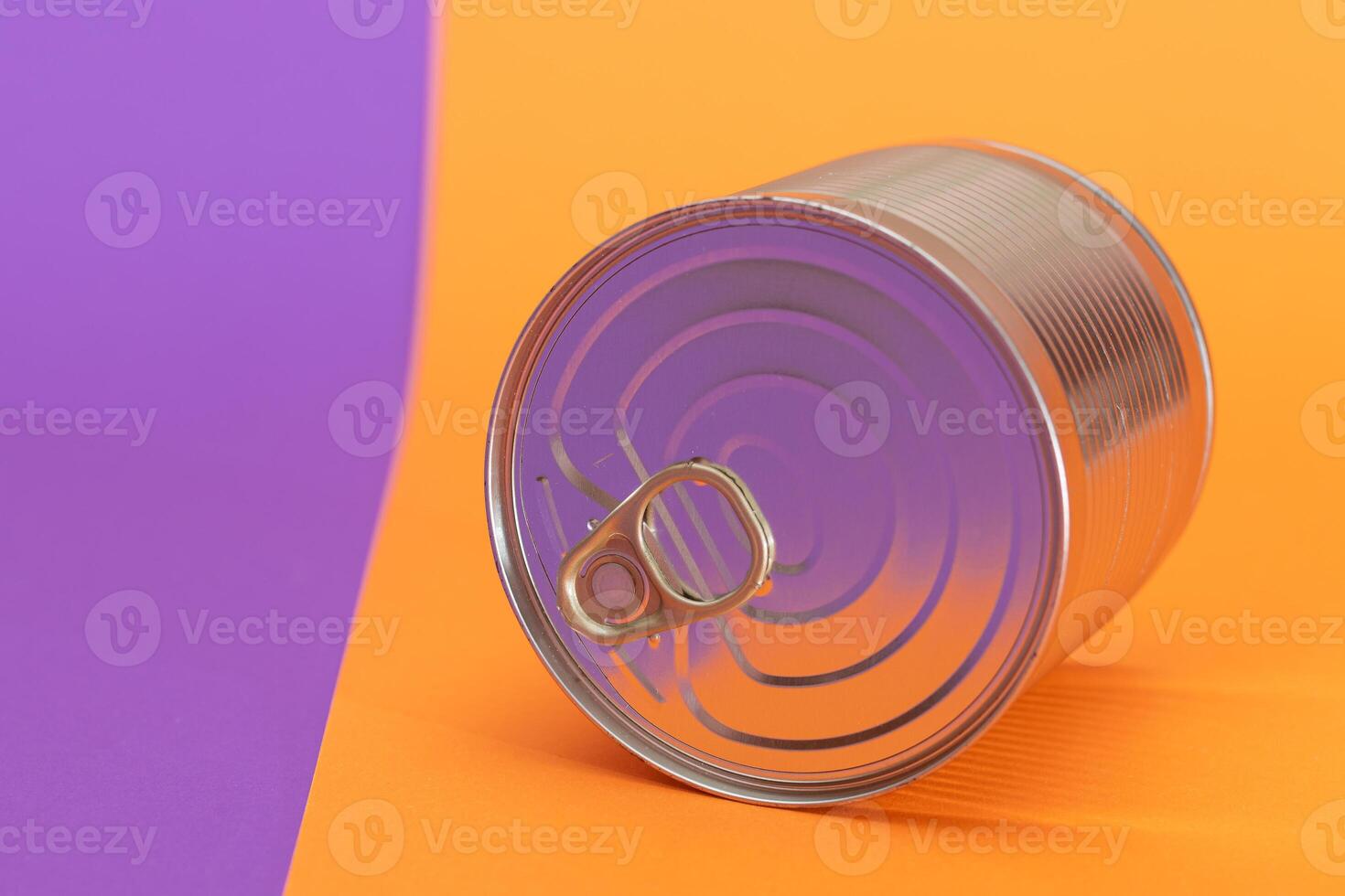 Unopened Tin Can on Split Orange and Violet Background. Canned Food. Aluminum Can for Safe and Long Term Storage of Food. Steel Sealed Food Storage Container photo