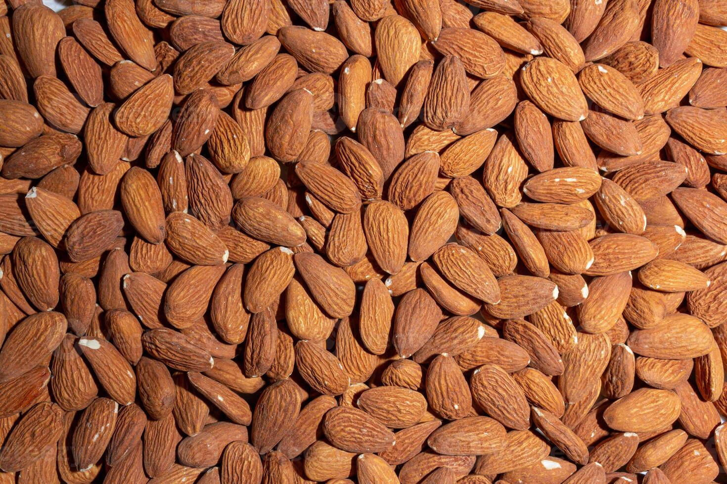 Scattered Almonds. Background from Almond Nuts. Natural High-Calorie Snacks photo
