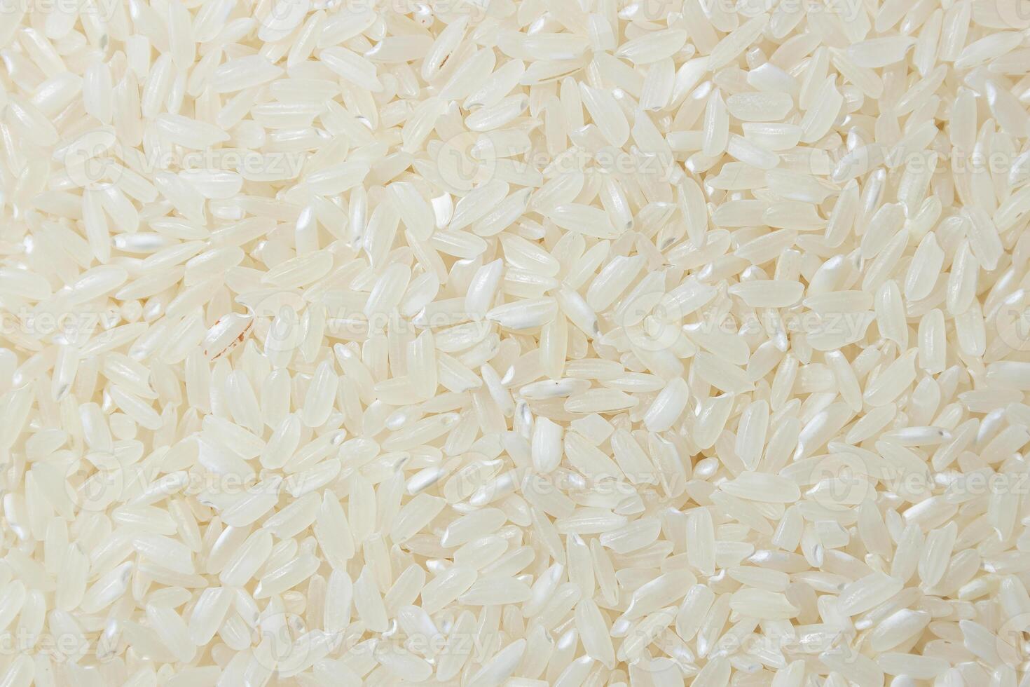Dry Uncooked White Rice Background - Top View, Flat Lay. Scattered Raw Long Grain Rice. Asian Cuisine and Culture. Healthy Eating Ingredients. Diet Food photo