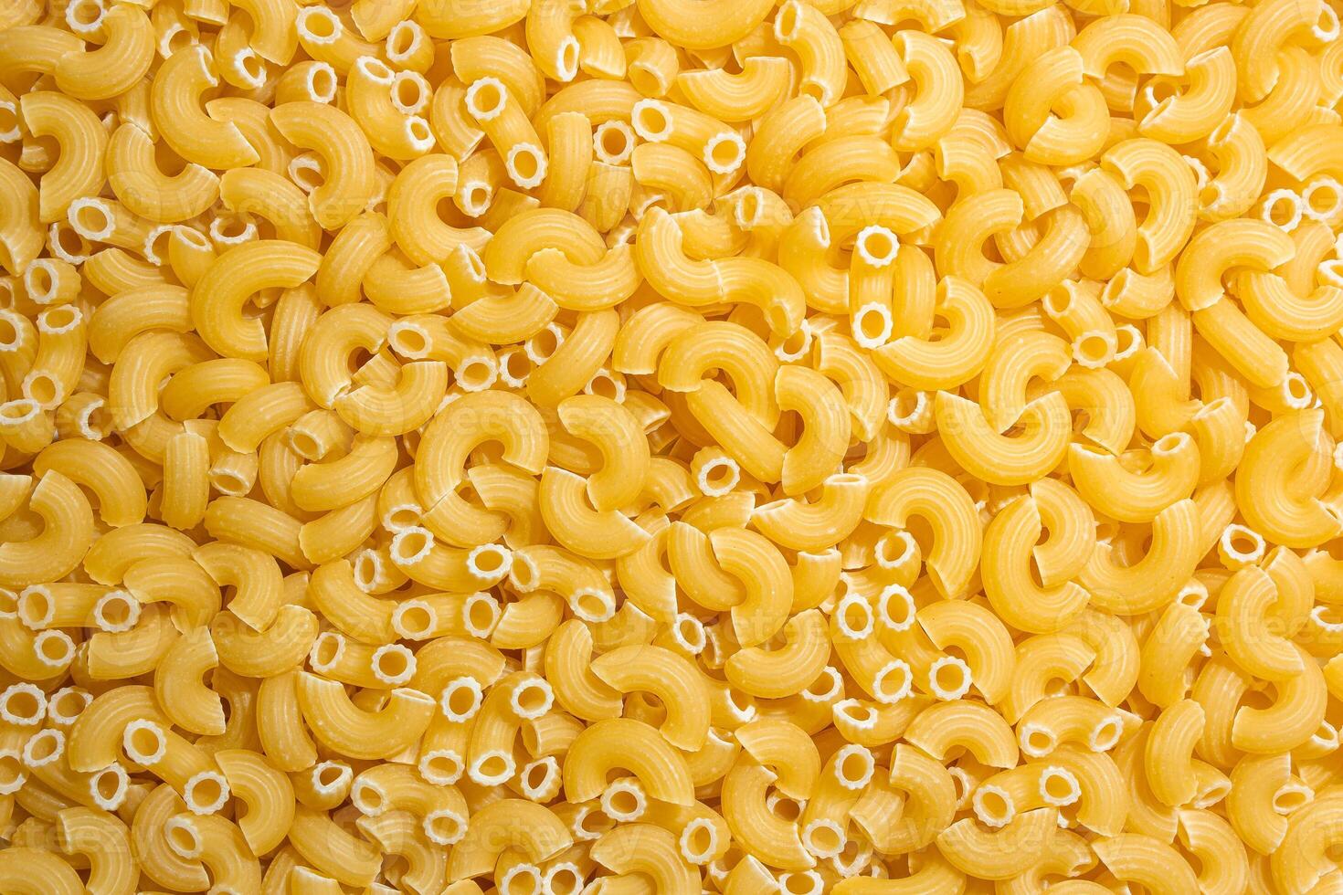 Uncooked Chifferi Rigati Pasta. A Culinary Canvas of Chifferi Rigati, Creating a Lively and Textured Background for Gourmet Cooking. Dry Pasta. Raw Macaroni - Top View, Flat Lay photo