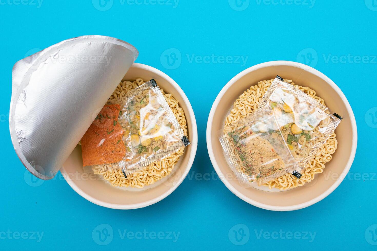 Opened Package with Uncooked Instant Noodles on Blue Background. Raw Pasta. Dry Asian Fast Food. Quick Lunch photo