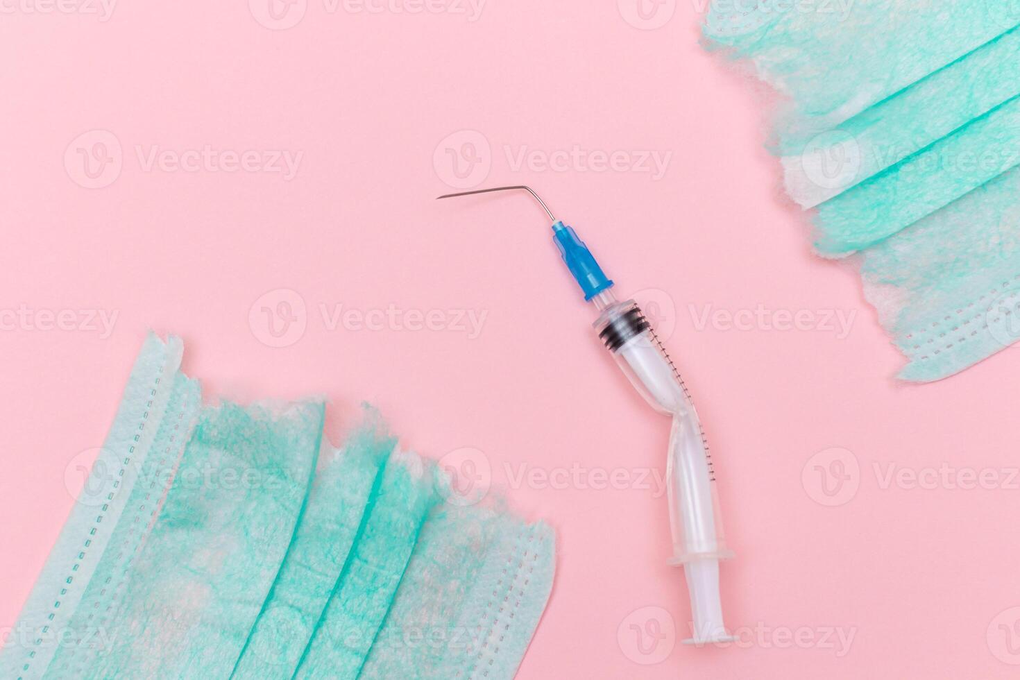 Anti Vaccine Movement and Anti Mask Concept - Broken Medical Syringe and Green Torn Medical Face Mask on the Pink Background. Pandemic and Lockdown End - Top View, Flat Lay photo