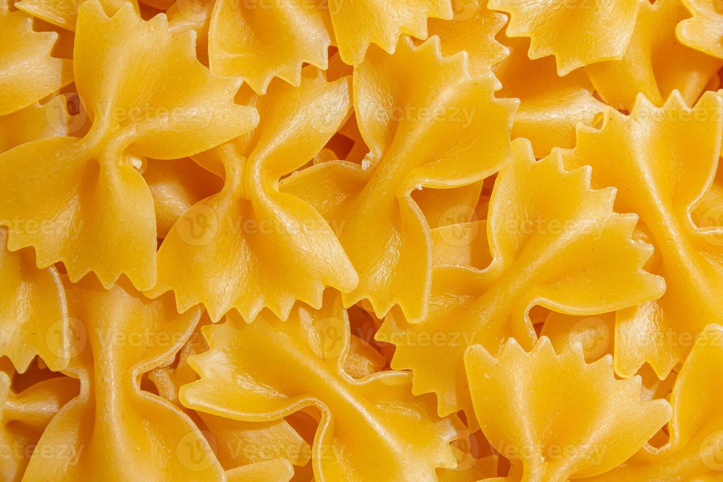 Uncooked Farfalle Pasta. A Culinary Canvas of Bow-Tie Macaroni, Creating a Lively and Textured Background for Gourmet Cooking. Dry Pasta. Raw Macaroni - Top View, Flat Lay photo