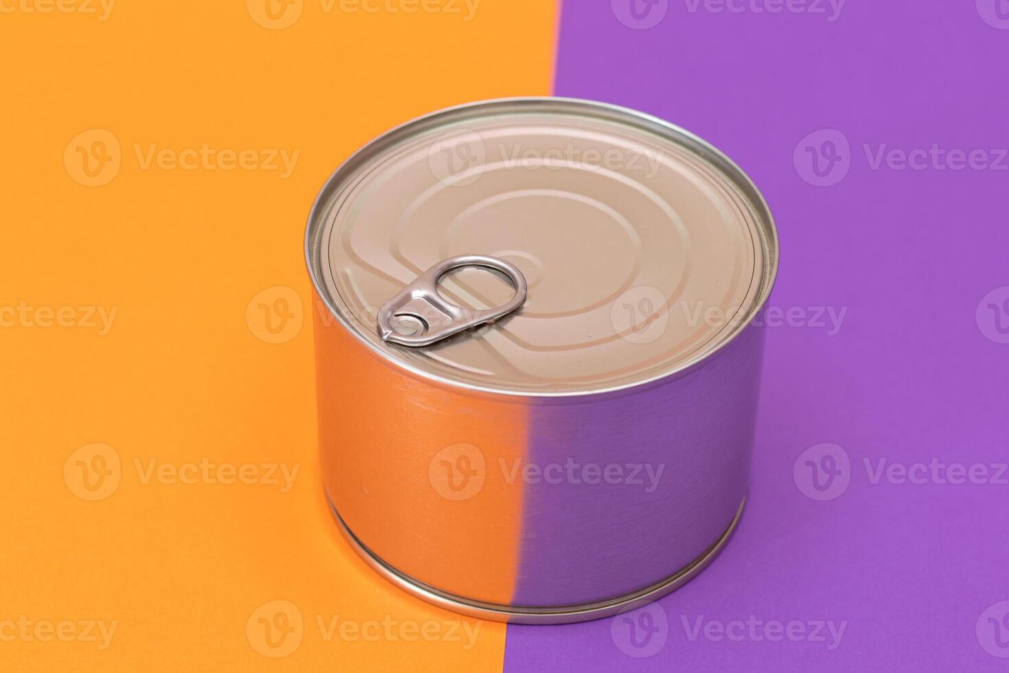 Unopened Tin Can on Split Orange and Violet Background. Canned Food. Aluminum Can for Safe and Long Term Storage of Food. Steel Sealed Food Storage Container photo