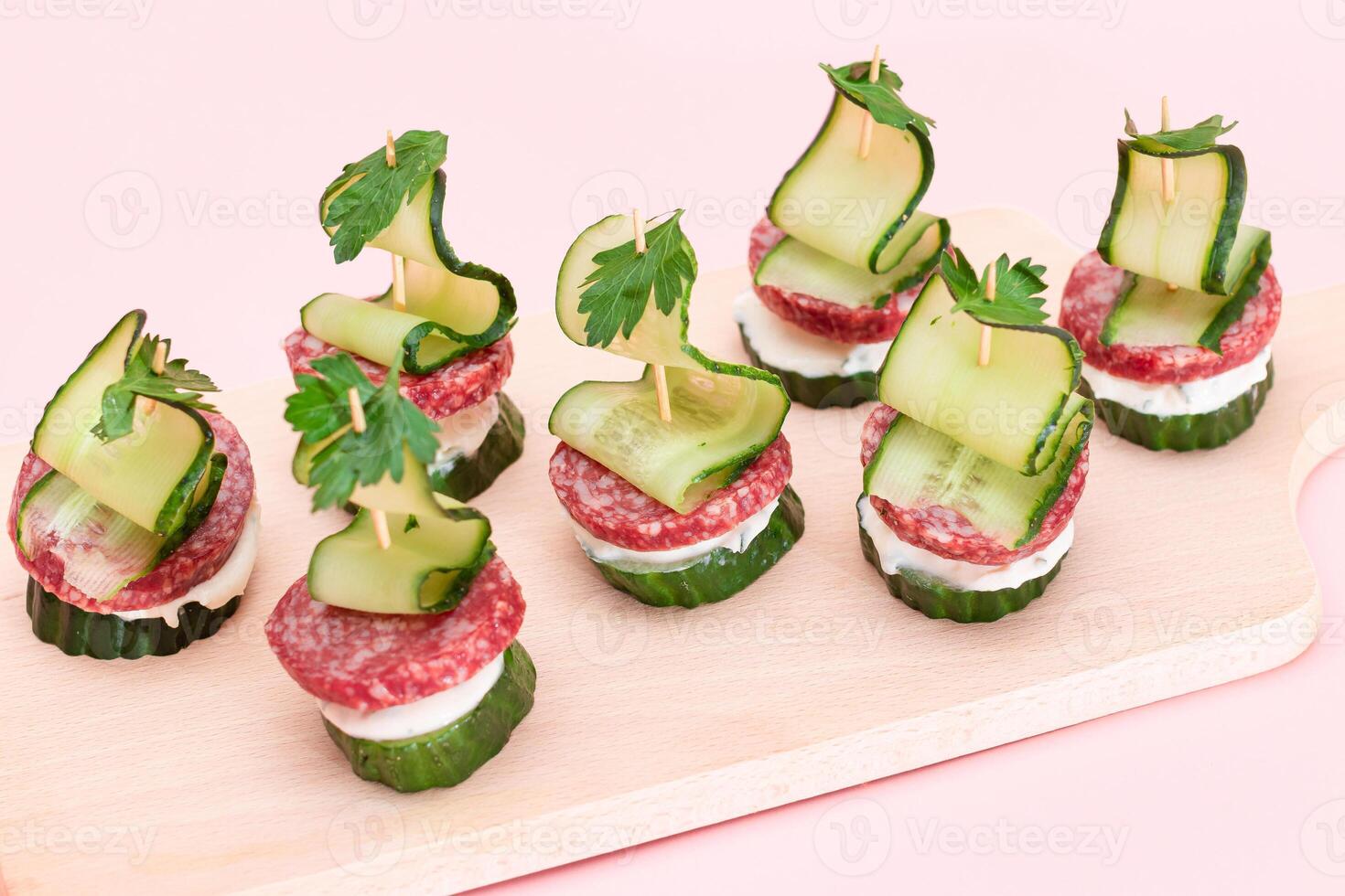 Canapes without Bread with Salami, Cucumber, Greens and Cream Cheese on Wooden Cutting Board. Easy Breakfast. Diet Food. Quick and Healthy Sandwiches. Healthy Snacks with Tasty Fillings photo