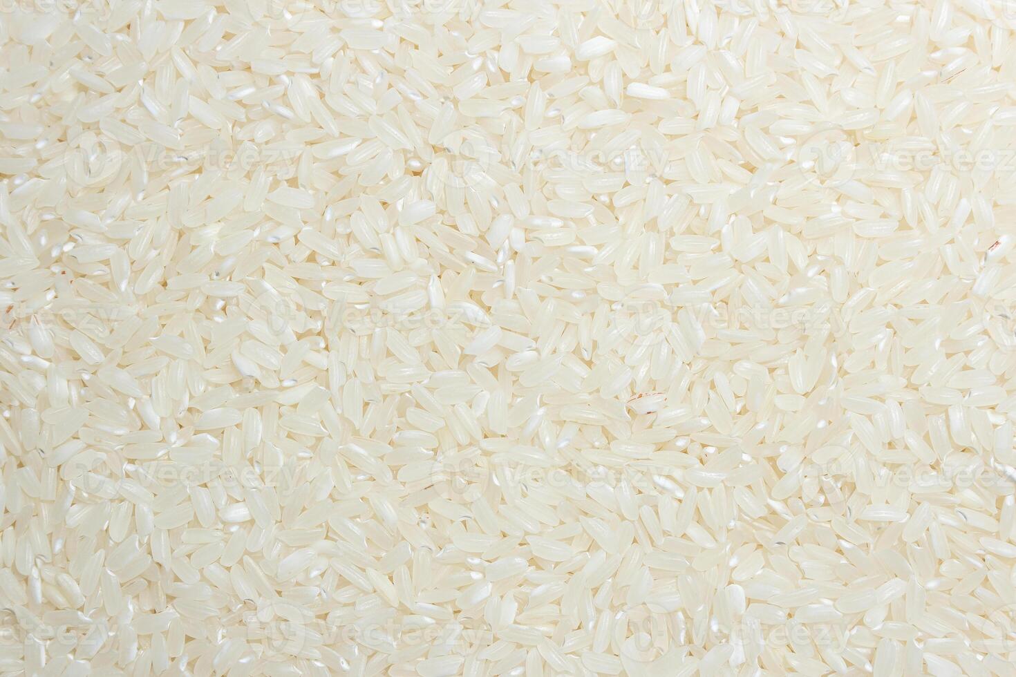 Dry Uncooked White Rice Background - Top View, Flat Lay. Scattered Raw Long Grain Rice. Asian Cuisine and Culture. Healthy Eating Ingredients. Diet Food photo