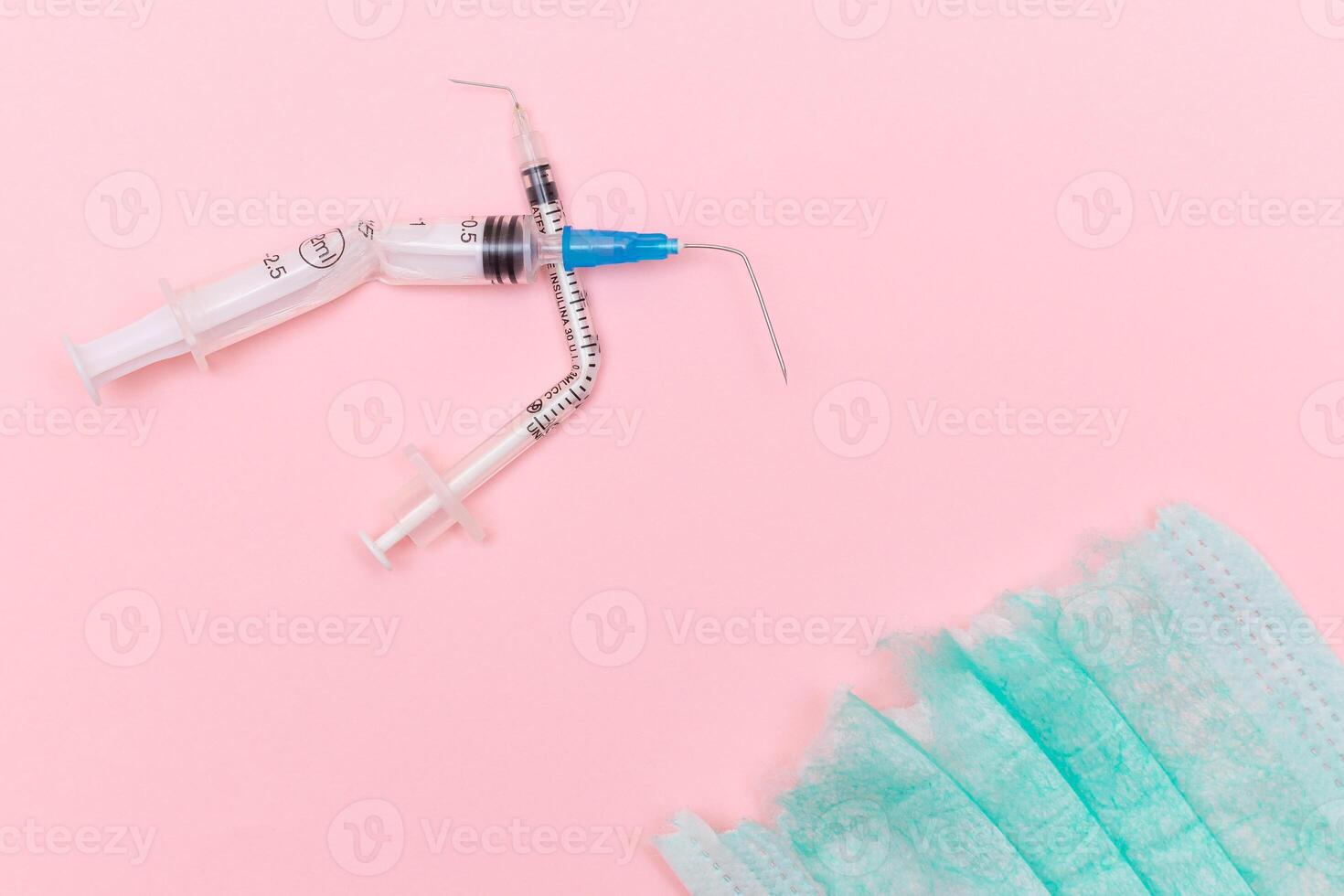 Anti Vaccine Movement and Anti Mask Concept - Broken Medical Syringe and Green Torn Medical Face Mask on the Pink Background. Pandemic and Lockdown End - Top View, Flat Lay photo