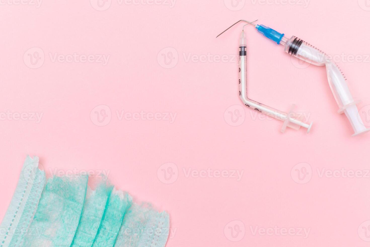 Anti Vaccine Movement and Anti Mask Concept - Broken Medical Syringe and Green Torn Medical Face Mask on the Pink Background. Pandemic and Lockdown End - Top View, Flat Lay photo