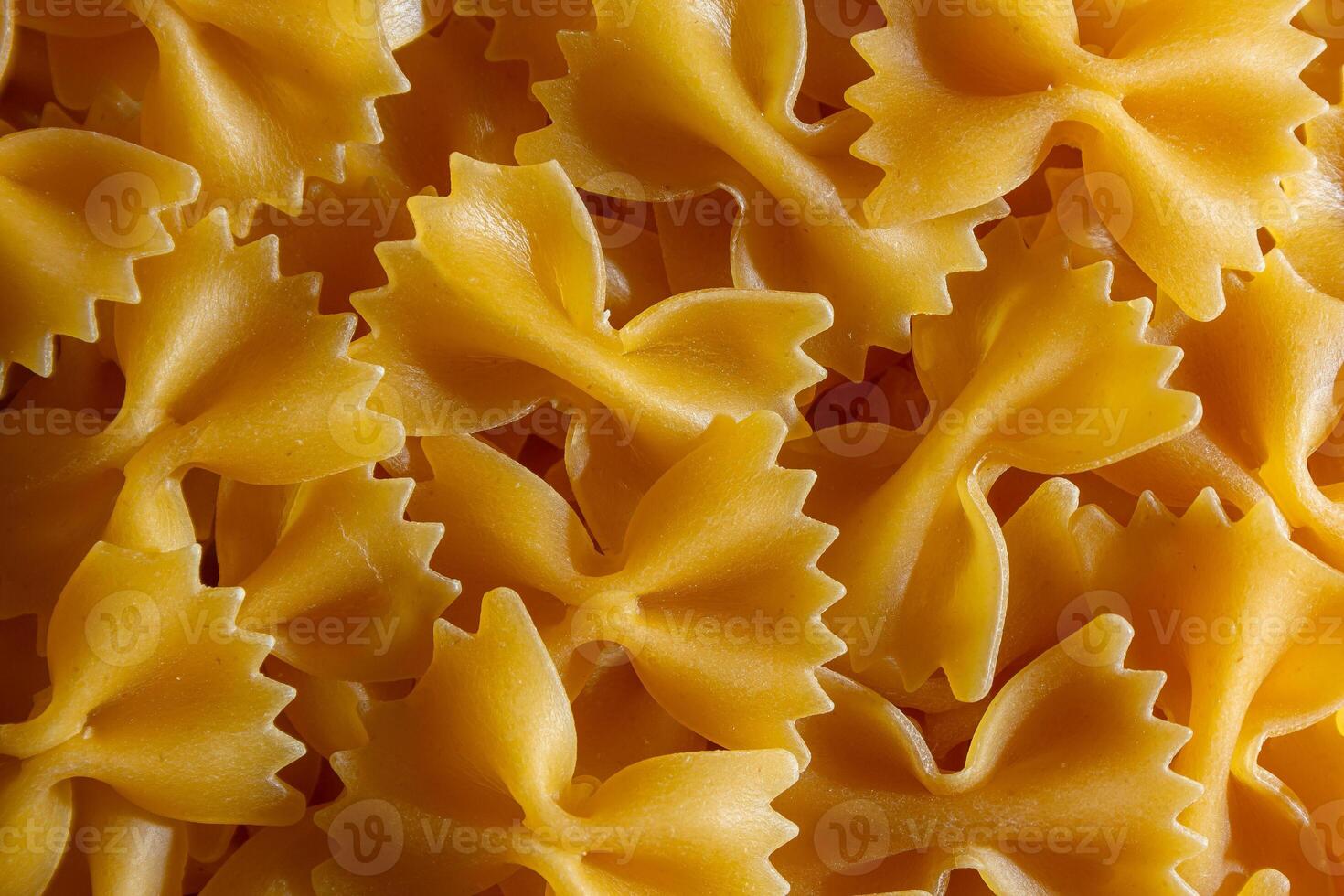 Uncooked Farfalle Pasta. A Culinary Canvas of Bow-Tie Macaroni, Creating a Lively and Textured Background for Gourmet Cooking. Dry Pasta. Raw Macaroni - Top View, Flat Lay photo
