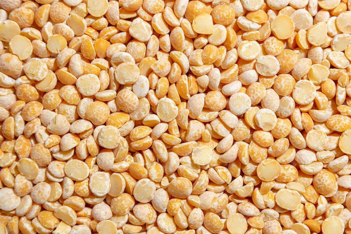 Uncooked Polished Split Peas Background. A Culinary Canvas of Dry Yellow Peas, Creating a Lively and Textured Background for Gourmet Cooking. Scattered Raw Polished Peas. Healthy Eating Ingredients photo