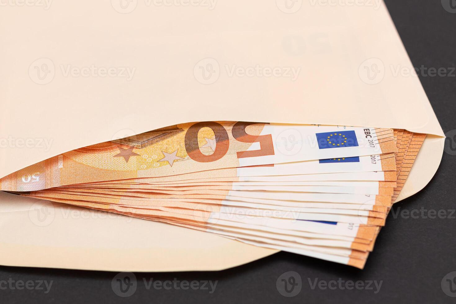An Orange Paper Envelope with Stack of 50-Euro Banknotes Inside. Salary in Cash. Tax-Free System. Euro Currency. Payments with No Taxes. Orange Paper Money. A Lot of Fifty-Euro Bills photo