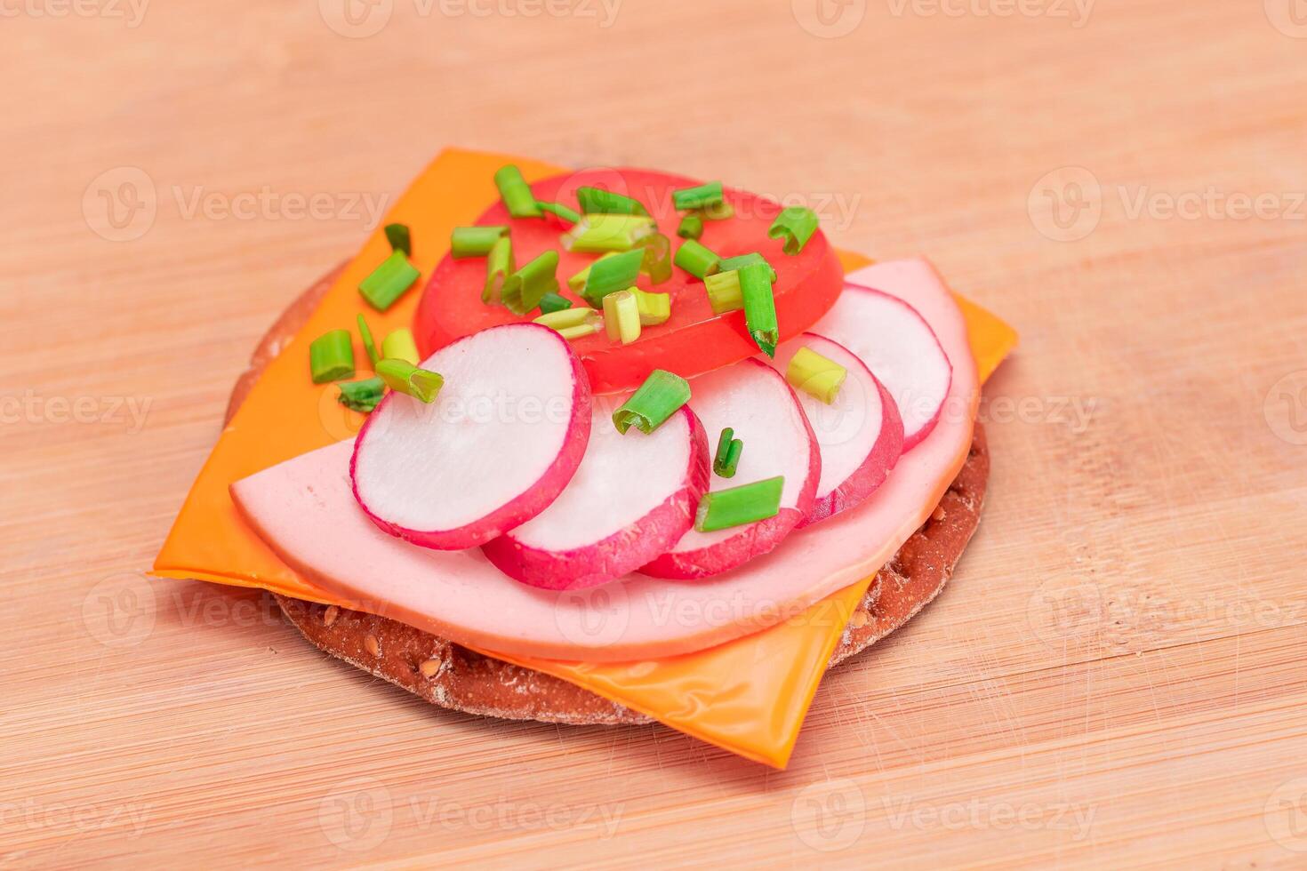 Crispy Cracker Sandwich with Tomato, Sausage, Cheese, Green Onions and Radish on Cutting Board. Easy Breakfast. Quick and Healthy Sandwiches. Crispbread with Tasty Filling. Healthy Dietary Snack photo