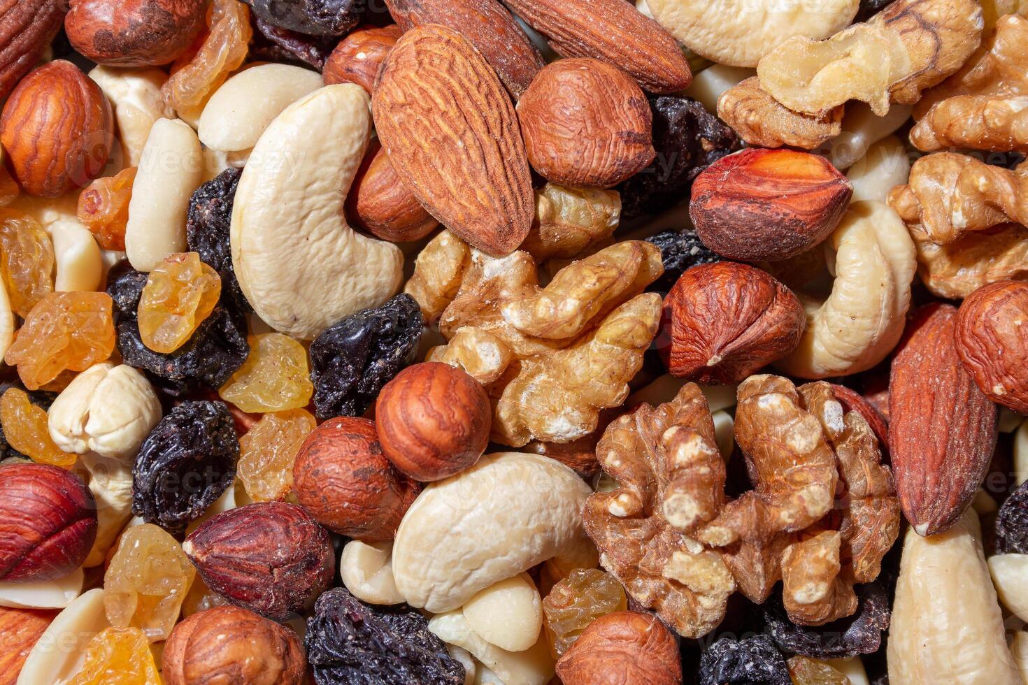Mixed Nuts. Almonds, Walnuts, Cashews, Peanuts, Hazelnuts, Dried Prunes and Raisins. Different Nut Mix. Background from Various Nuts and Dried Fruits photo
