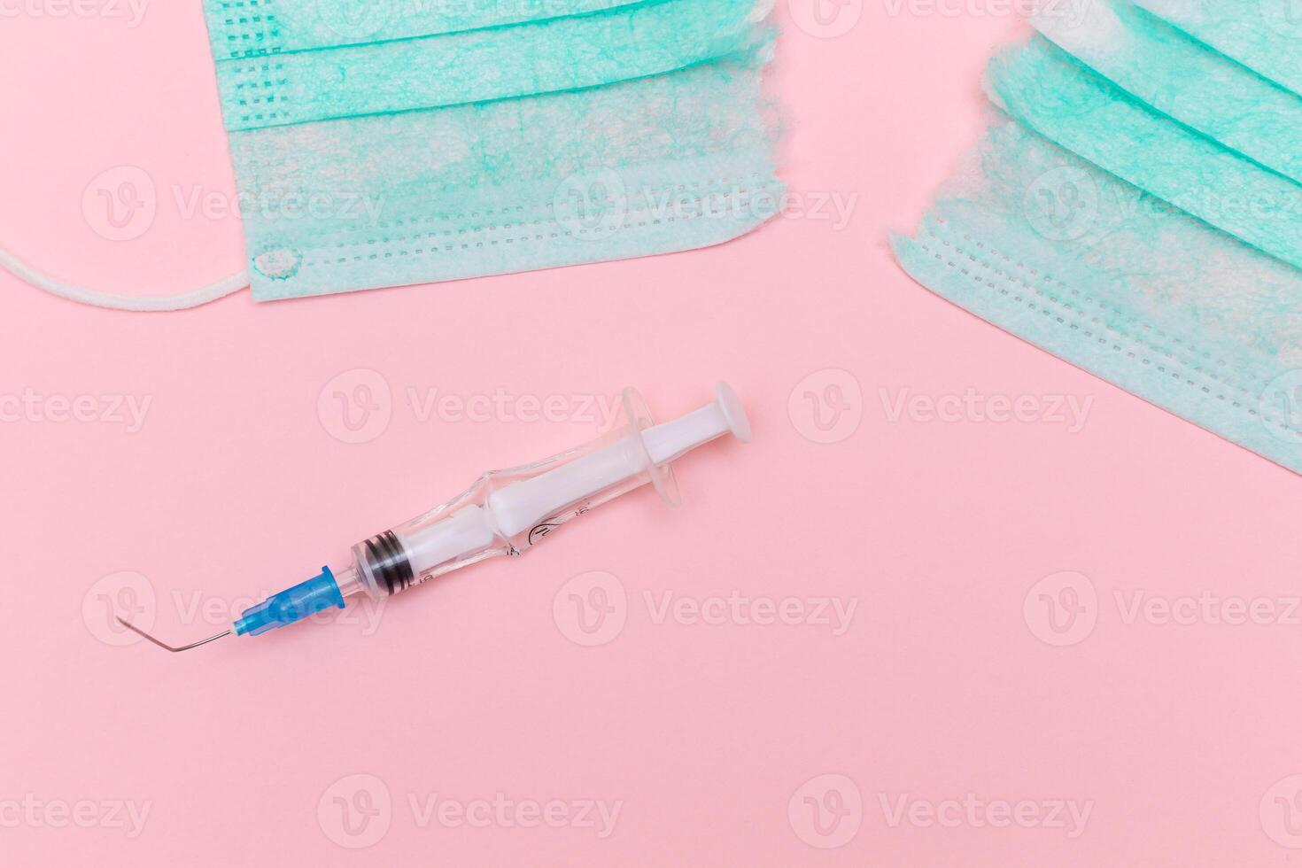 Anti Vaccine Movement and Anti Mask Concept - Broken Medical Syringe and Green Torn Medical Face Mask on the Pink Background. Pandemic and Lockdown End - Top View, Flat Lay photo