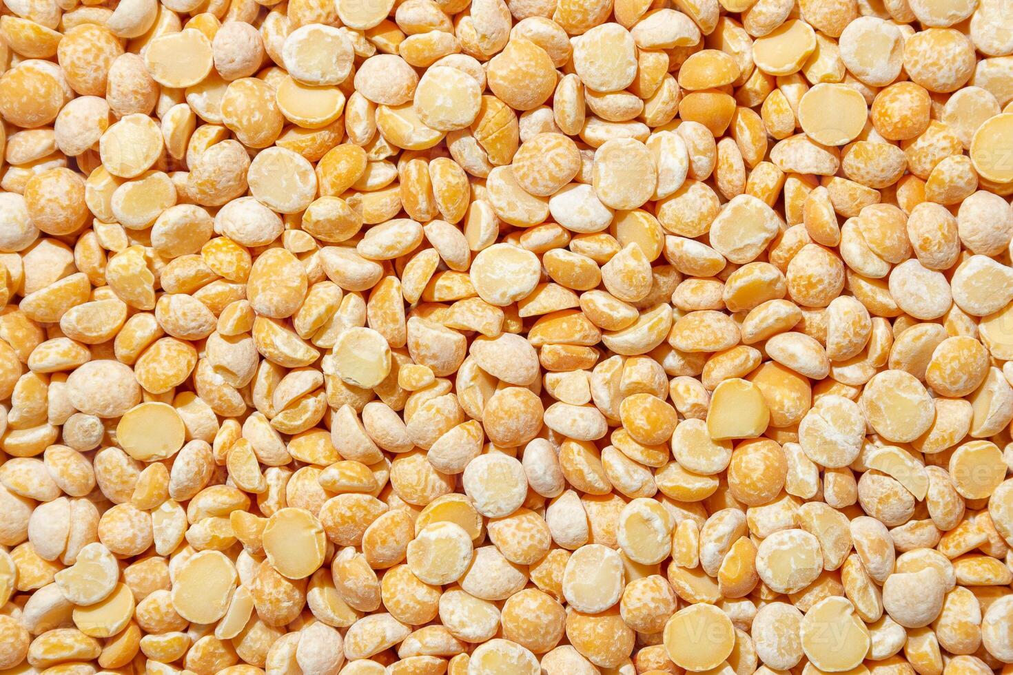 Uncooked Polished Split Peas Background. A Culinary Canvas of Dry Yellow Peas, Creating a Lively and Textured Background for Gourmet Cooking. Scattered Raw Polished Peas. Healthy Eating Ingredients photo