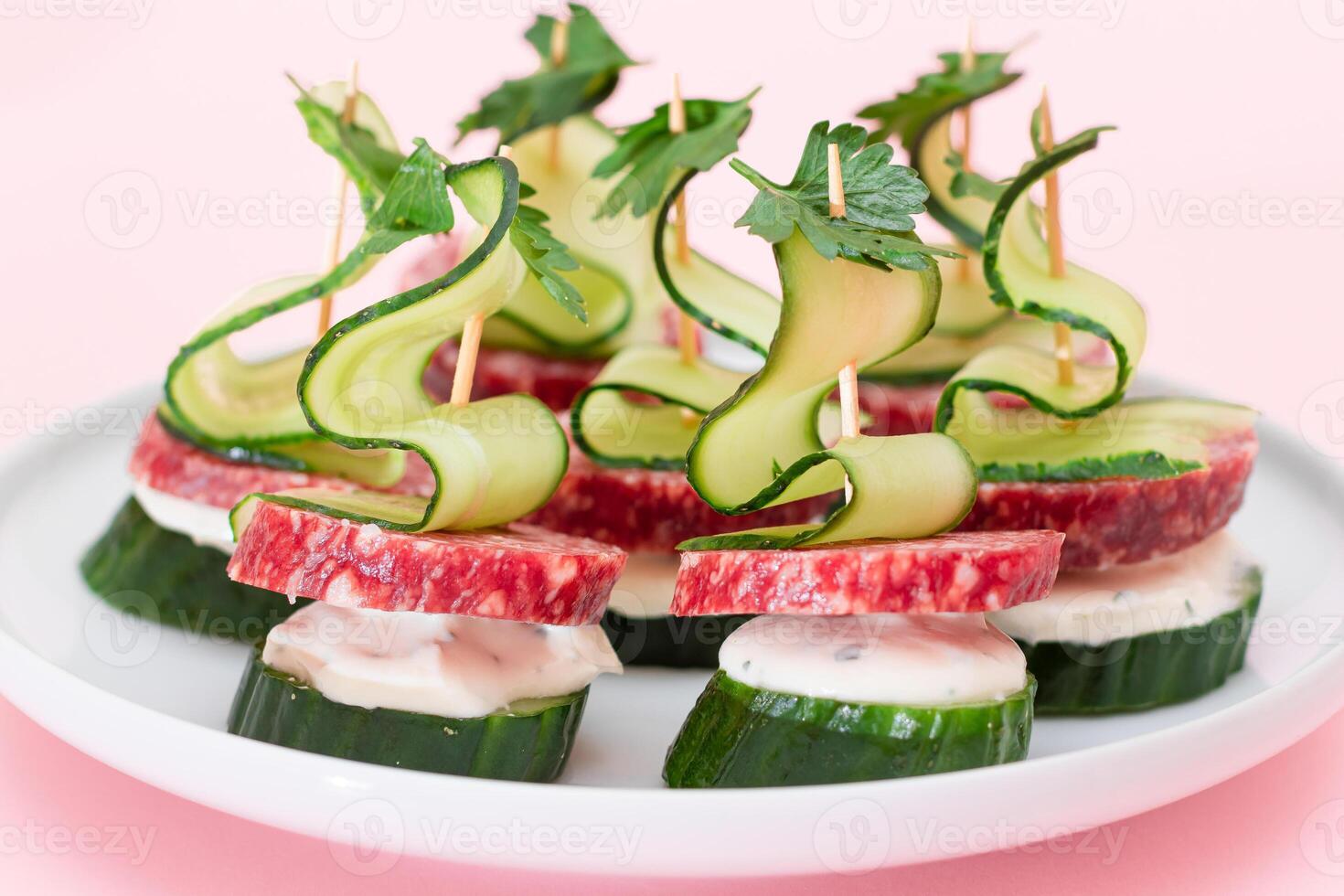 Canapes without Bread with Salami, Cucumber, Greens and Cream Cheese on White Plate. Easy Breakfast. Diet Food. Quick and Healthy Sandwiches. Healthy Snacks with Tasty Fillings photo