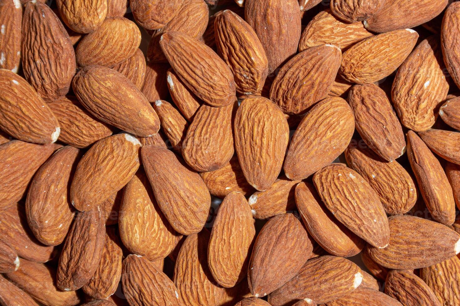 Scattered Almonds. Background from Almond Nuts. Natural High-Calorie Snacks photo