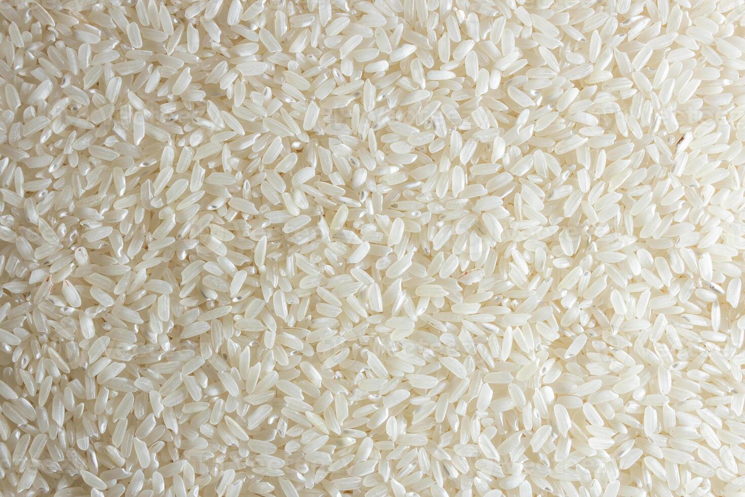 Dry Uncooked White Rice Background - Top View, Flat Lay. Scattered Raw Long Grain Rice. Asian Cuisine and Culture. Healthy Eating Ingredients. Diet Food photo