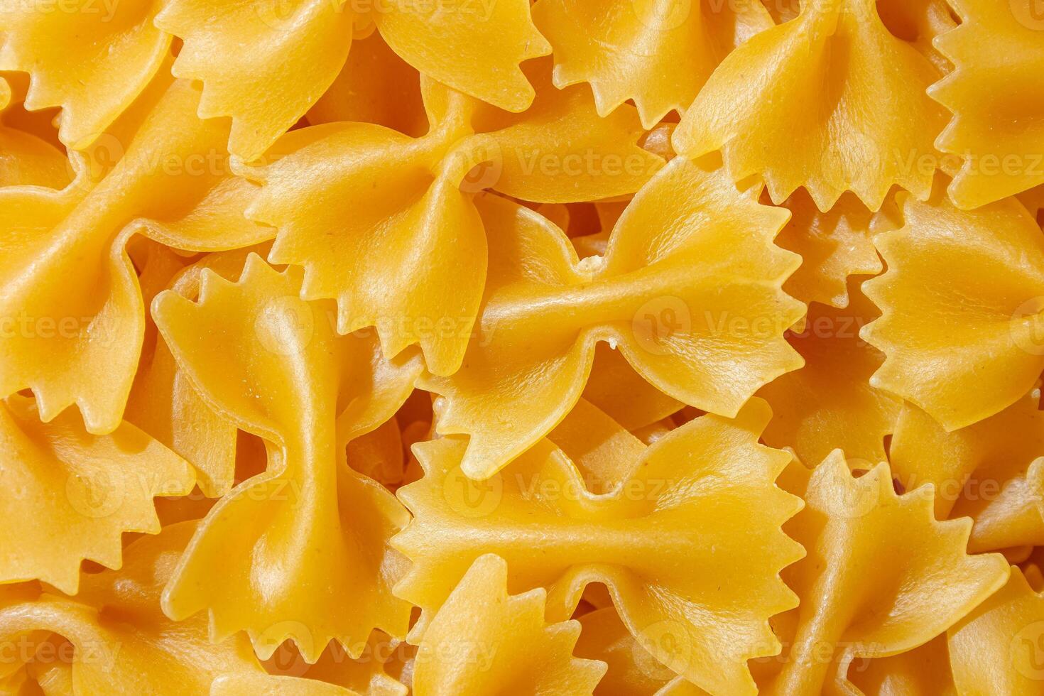 Uncooked Farfalle Pasta. A Culinary Canvas of Bow-Tie Macaroni, Creating a Lively and Textured Background for Gourmet Cooking. Dry Pasta. Raw Macaroni - Top View, Flat Lay photo