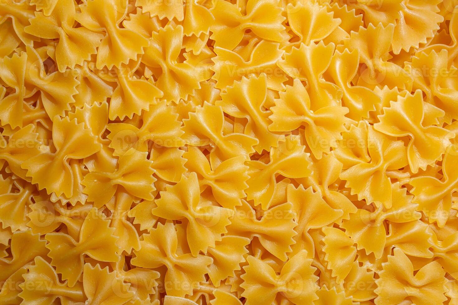 Uncooked Farfalle Pasta. A Culinary Canvas of Bow-Tie Macaroni, Creating a Lively and Textured Background for Gourmet Cooking. Dry Pasta. Raw Macaroni - Top View, Flat Lay photo