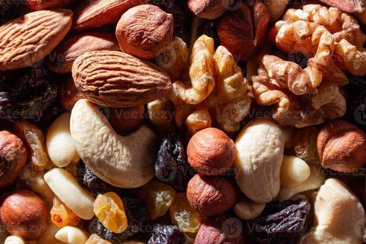 Mixed Nuts. Almonds, Walnuts, Cashews, Peanuts, Hazelnuts, Dried Prunes and Raisins. Different Nut Mix. Background from Various Nuts and Dried Fruits photo