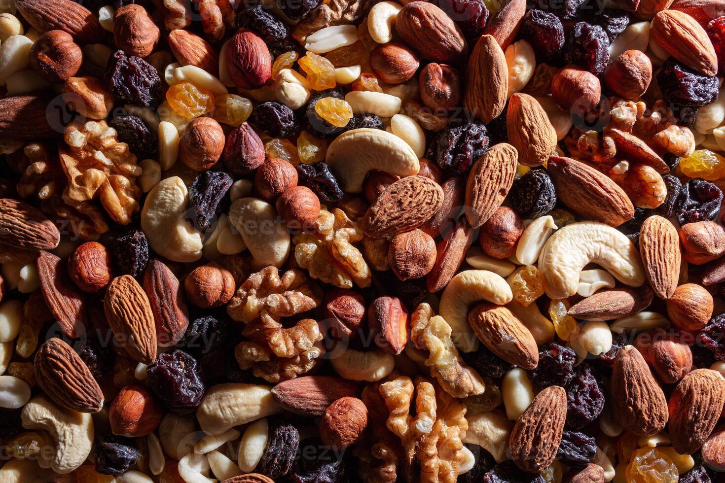 Mixed Nuts. Almonds, Walnuts, Cashews, Peanuts, Hazelnuts, Dried Prunes and Raisins. Different Nut Mix. Background from Various Nuts and Dried Fruits photo